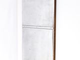 mirror in the corner of a room with white walls and a white floor