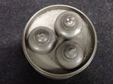 three donuts in a tin sitting on a table