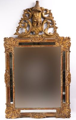 an antique mirror with a gold frame and a bird on top of it