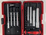 Les outils se trouvent dans la mallette rouge posée sur la table blanche.