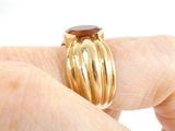 a person holding a ring with a brown stone on it
