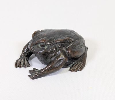 statue d'une grenouille assise sur une surface blanche