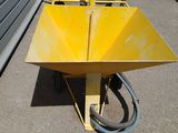 a yellow wheelbarrow on the ground next to a building