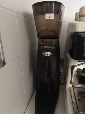 a coffee grinder sitting next to a toaster on a counter