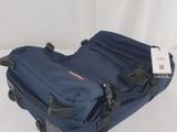 une valise bleue posée sur une surface blanche