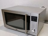 a silver microwave oven sitting on a white table