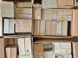 Plusieurs cartons sont empilés les uns sur les autres sur un plancher en bois