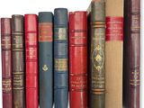 plusieurs vieux livres sont alignés sur une surface blanche