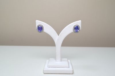 paire de boucles d'oreilles en saphir bleu et diamants, présentées sur un socle blanc