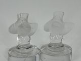 pair of clear glass figurines of a man and a woman