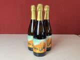 Deux bouteilles de vin sont posées sur un comptoir, avec un mur rouge en arrière-plan.