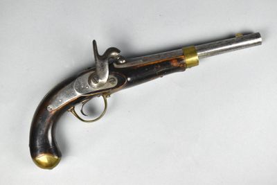 un vieux pistolet posé sur une surface blanche