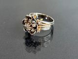 an image of a silver and gold ring on a black surface