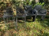 quatre chaises et une table posées dans l'herbe, devant des arbres