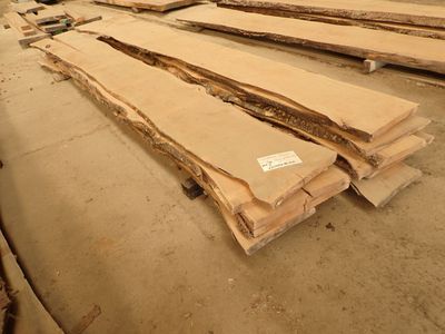 de nombreuses pièces de bois posées par terre dans un entrepôt