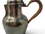 a silver coffee pot with a handle on a white background