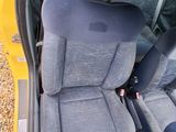 a yellow car with two black seats in the back of it