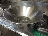 un grand saladier en métal posé sur une cuisinière
