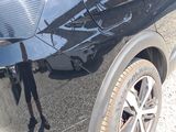 the rear end of a black car with a broken bumper