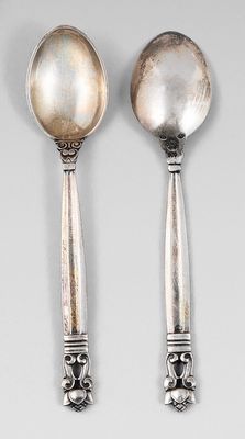 deux cuillères en argent et une cuillère posées sur une surface blanche