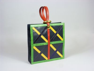 green, yellow, and black gift bag with red ribbon on white background
