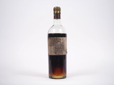 une vieille bouteille d'alcool posée sur une surface blanche