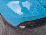 a close up of a blue car that is parked on the street