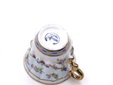 a small tea cup with a saucer on top of it