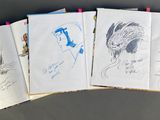 four books with drawings on them sitting on top of a table