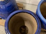 two blue vases sitting on a pallet next to each other
