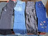 several pairs of jeans sitting on top of a pallet in front of a cardboard box