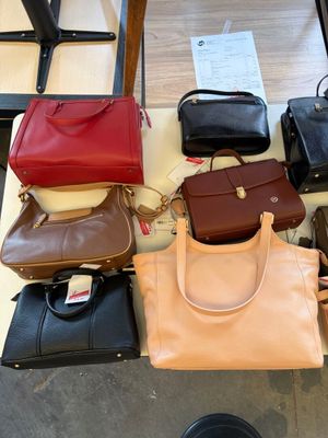 a lot of purses sitting on a table together