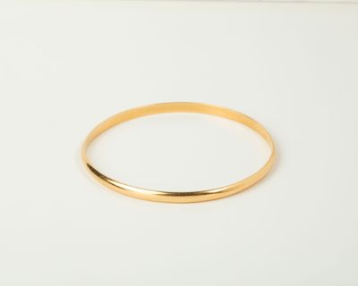a close up of a gold ring on a white surface