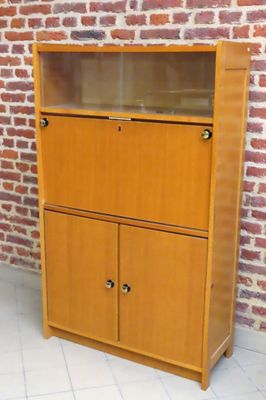 une armoire en bois à deux portes, avec un mur de briques en arrière-plan