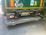 a garbage truck that is parked on the side of the road