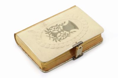 un petit livre sur lequel est représenté un oiseau, posé sur une table