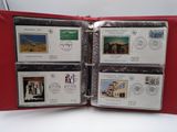 four stamps are in a red folder on a white surface
