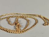 two gold chains are laying on top of each other on a white surface