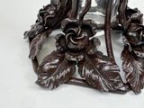 a metal candle holder with flowers and leaves on it