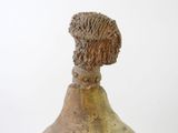 a brown vase with a face on it on a white surface