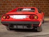 a red sports car parked in front of a brick wall