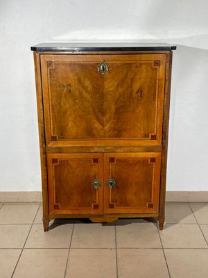 a wooden cabinet with a marble top on a tiled floor