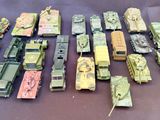beaucoup de petits véhicules militaires et de camions miniatures posés sur une table