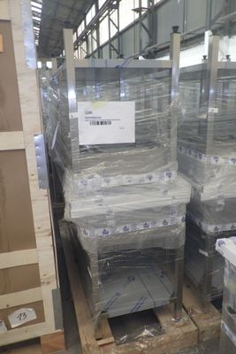 Des cartons contenant des matelas sont empilés sur des palettes dans un entrepôt