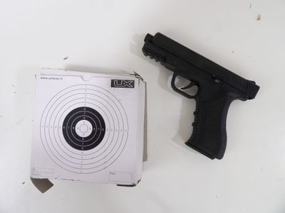un pistolet et une cible posés sur une table blanche