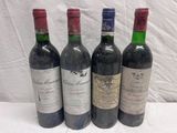 four bottles of wine are lined up on a table