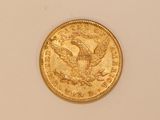 a close up of a gold coin on a white surface