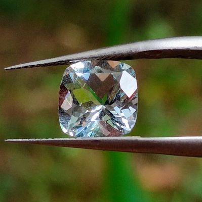 un gros plan d'un diamant tenu par une pince