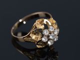 gros plan d'une bague en or et diamants sur une surface noire