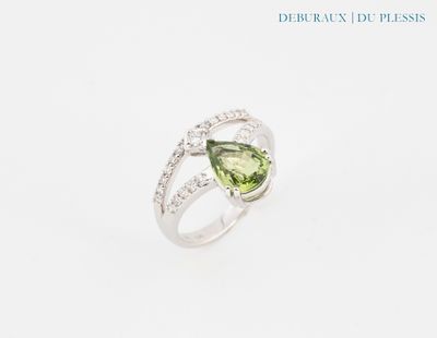 un gros plan d'une bague sertie d'une tourmaline verte et de diamants